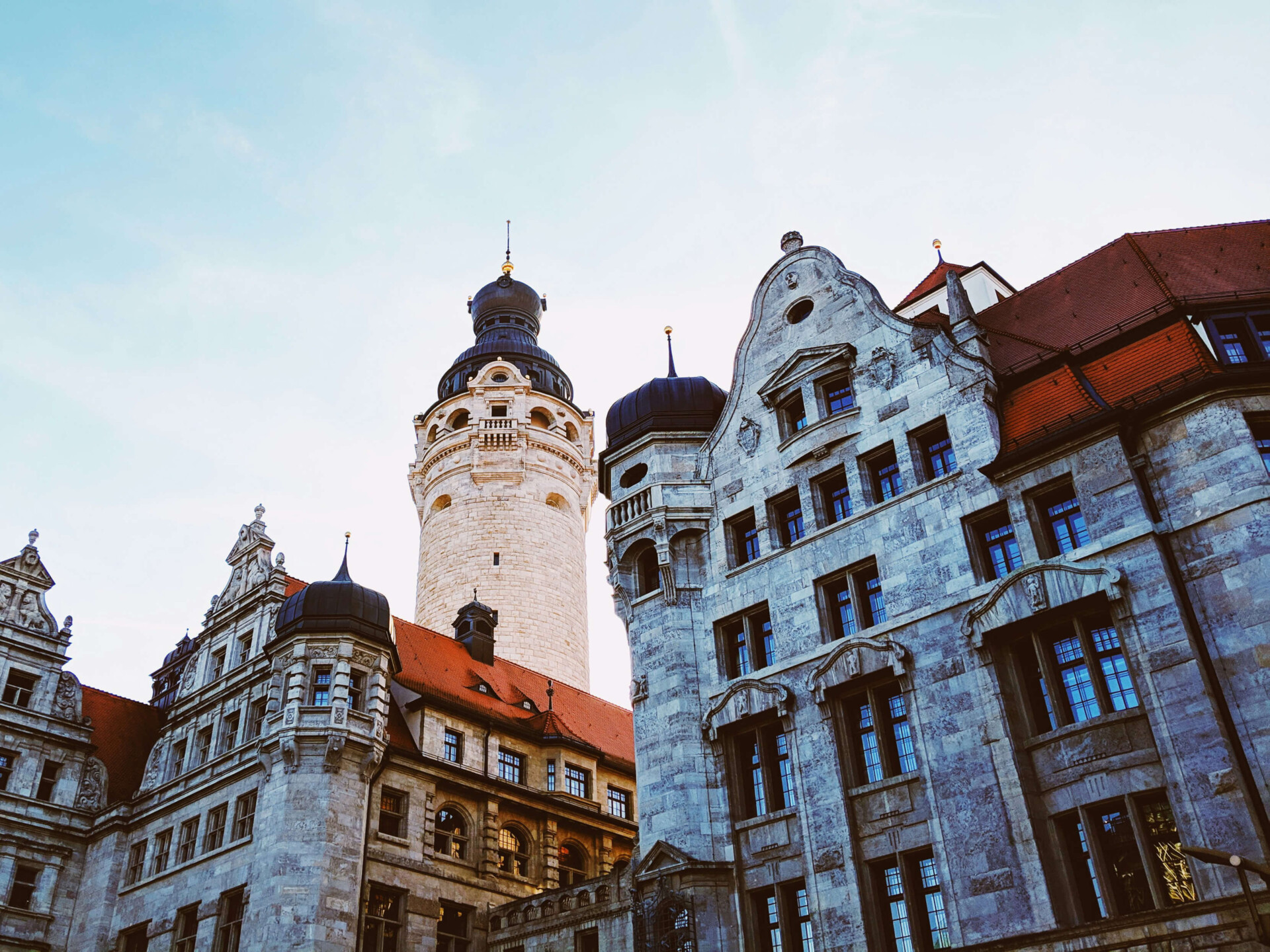 Fotografie des neuen Rathauses in Leipzig. Im Hintergrund ragt der Rathausturm in den Himmel.